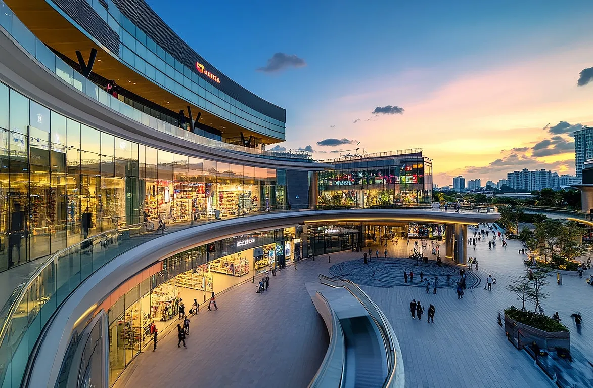 Shopping mall with glass facade at sunset