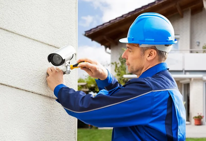 Engineer in a hard hat installing a CCTV camera